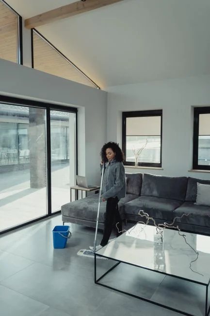 A hotel housekeeper neatly stacks fresh towels in a luxurious room setting.
